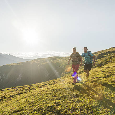 Paar wandert mit Bergpanorma der Nockberge im UNESCO Biosphärenpark 