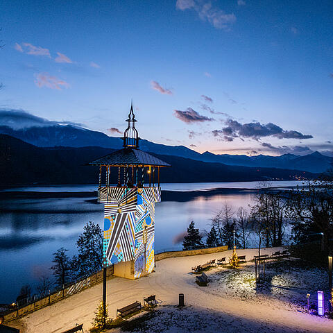Ausblick auf den beleuchteten Turm am Millstätter Lichtweg mit dem Millstätter See im Hintergrund