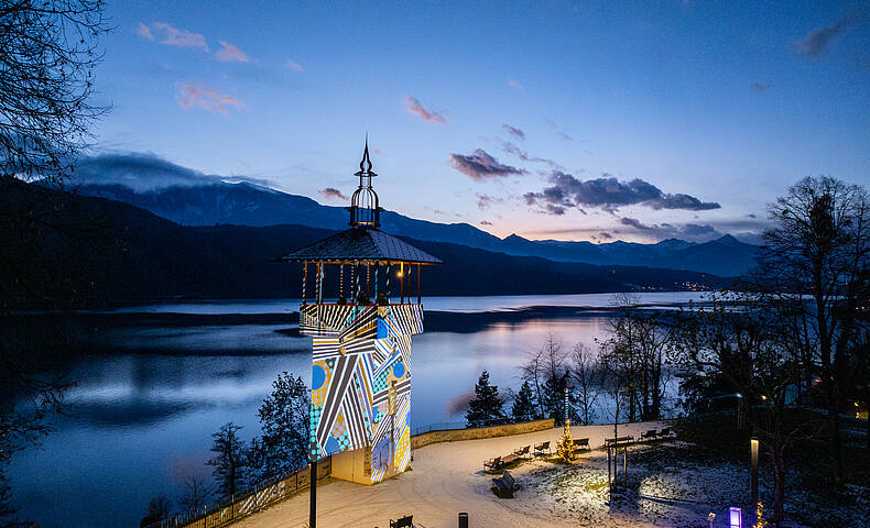 Ausblick auf den beleuchteten Turm am Millstätter Lichtweg mit dem Millstätter See im Hintergrund