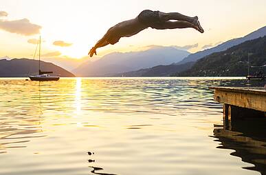 Ein erfrischender Sprung ins Wasser des Millstätter Sees bei Sonnenuntergang © Gert Perauer_MBN Tourismus