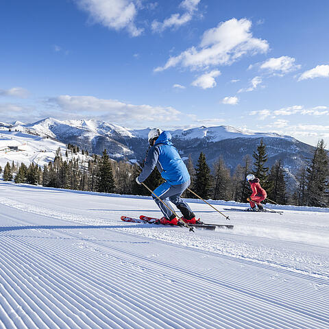 2 Skifahrer fahren nebeneinander die Piste im Skigebiet Bad Kleinkirchheim hinunter