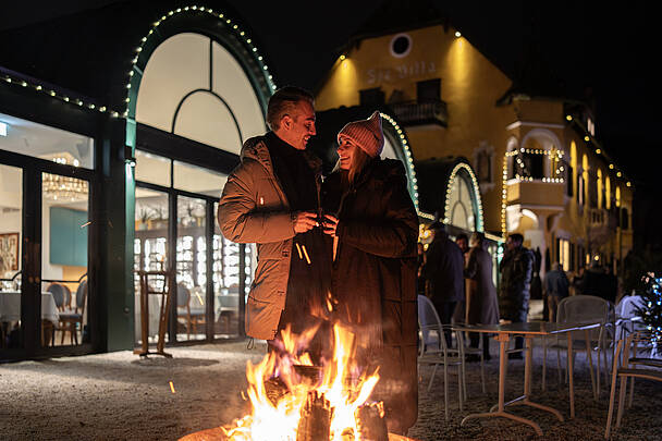 Pärchen wärmt sich am Feuer am Millstätter Kirchtag