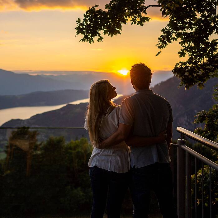 Pärchen sehen sich zusammen am Sternenbalkon den Sonnenuntergang an