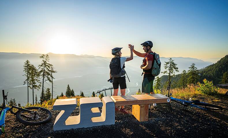 2 Personen feiern ihren Gipfelsieg am Goldeck beim Zeitplatz