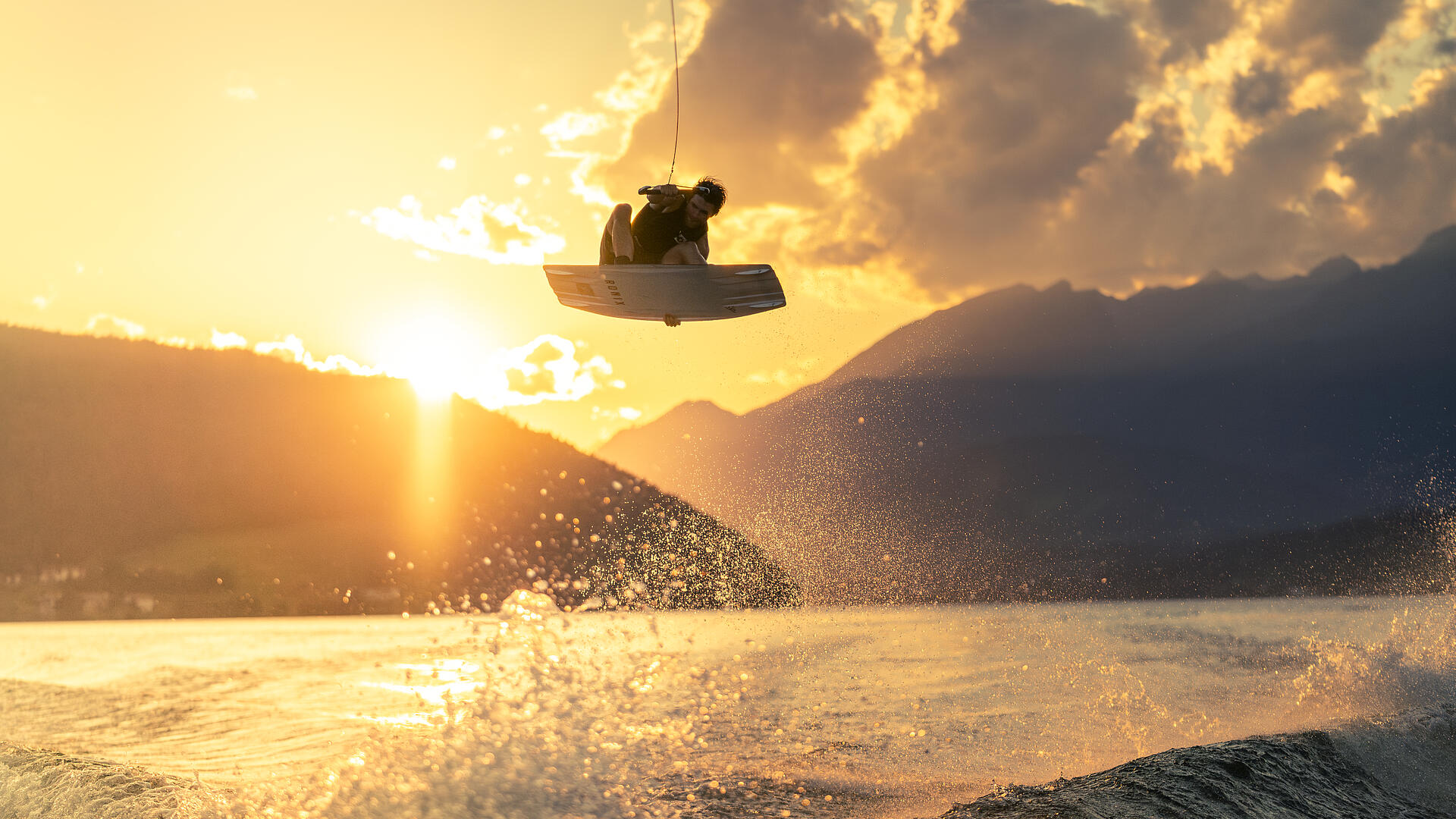 Junger Mann fährt Wakeboard am Millstätter See
