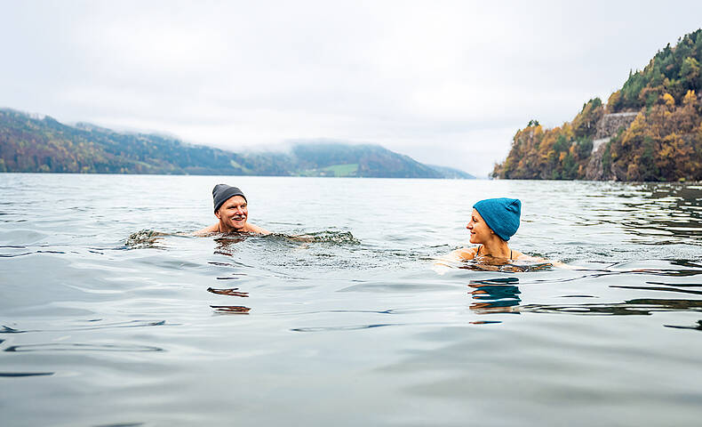 Gesundes Kaltbaden im Millstätter See 2 Personen schwimmen im kalten Millstätter See