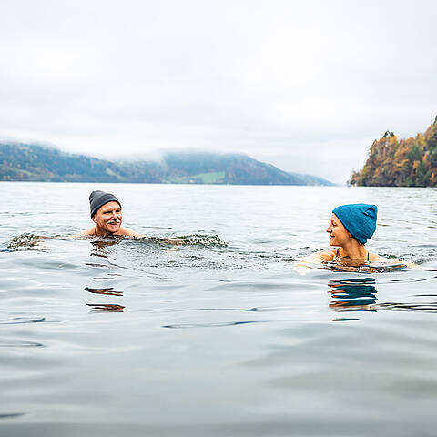Gesundes Kaltbaden im Millstätter See 2 Personen schwimmen im kalten Millstätter See