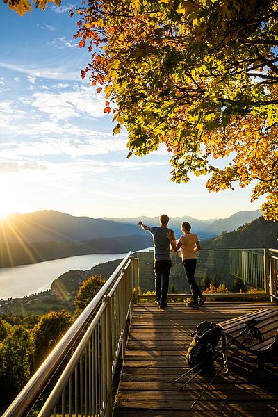 Pärchen steht am Sternenbalkon im Herbst mit Blick auf den Millstätter See