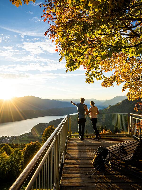 Pärchen steht am Sternenbalkon im Herbst mit Blick auf den Millstätter See